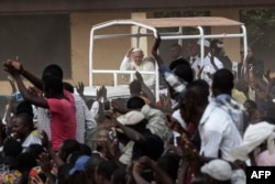 Pope Francis (C) waves as he visits the Koudoukou school, to meet people from the muslim community, after leaving the Central Mosque in the PK5 neighborhood in Bangui, Central African Republic, Nov. 30, 2015.