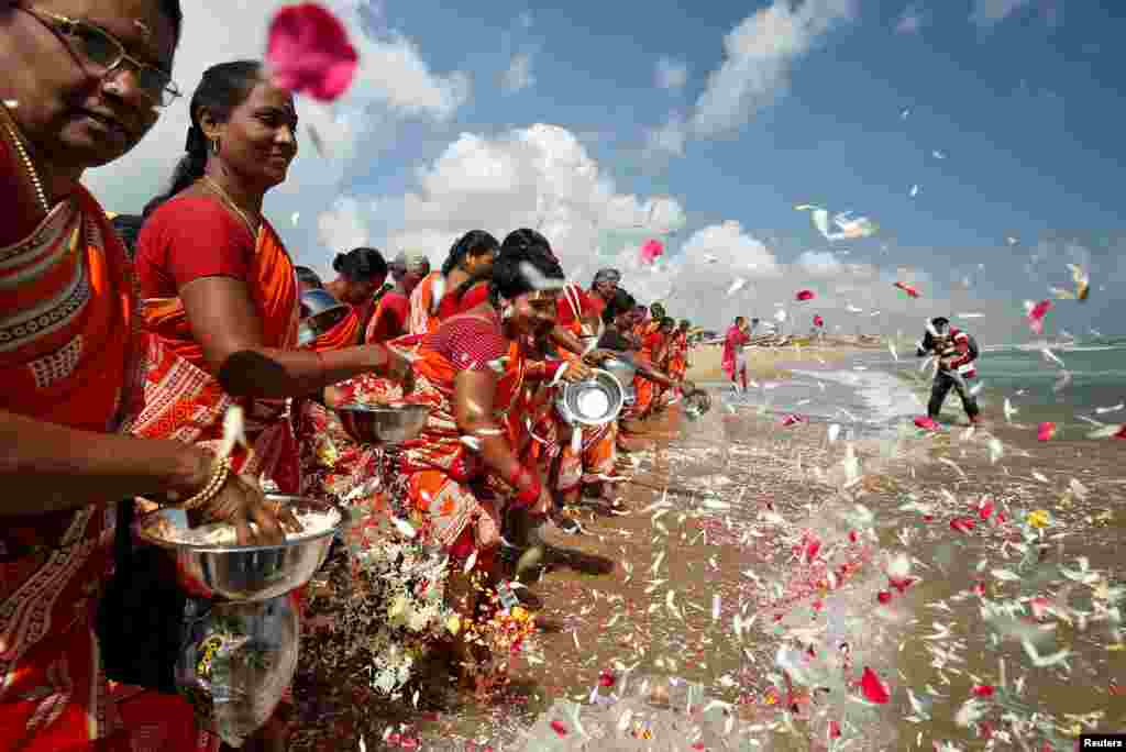 Women scatter flower petals in the waters of the Bay of Bengal during a prayer ceremony for the victims of the 2004 tsunami on the 15th anniversary of the disaster, at Marina beach in Chennai, India.