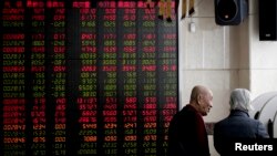 Investors chat near an electronic board displaying stock prices at a brokerage house in Beijing, Jan. 18, 2019. Chinese stocks rose Friday on signs of possible progress in negotiations over Beijing's tariff war with Washington. 
