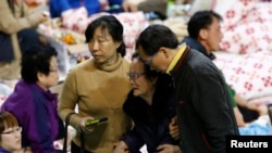 The family member of a missing passenger who was on South Korean ferry Sewol, which sank in the sea off Jindo, is helped as she cries while waiting for news from the rescue team, at a gym in Jindo, Apr. 18, 2014. 