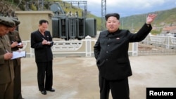 North Korean leader Kim Jong Un (R) gives field guidance during a visit to a construction site in this undated photo released by North Korea's Korean Central News Agency (KCNA) in Pyongyang, Sept. 14, 2015.