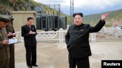 North Korean leader Kim Jong Un (R) gives field guidance during a visit to the construction site of the Paektusan Hero Youth Power Station near completion in this undated photo released by North Korea's Korean Central News Agency (KCNA) in Pyongyang, Sept