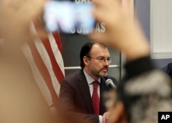 A visitor takes a phone photo of Mexico's Secretary of Foreign Relations Luis Videgaray at the Consulate General of Mexico in Los Angeles, Sept. 12, 2017. Videgaray announced support for young immigrants whose protection from deportation is being terminated.