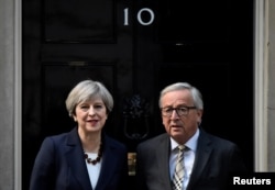 FILE - Britain's Prime Minister Theresa May welcomes Head of the European Commission, President Jean-Claude Juncker to Downing Street in London, April 26, 2017.