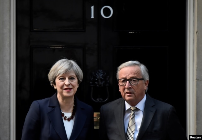 FILE - Britain's Prime Minister Theresa May welcomes Head of the European Commission, President Jean-Claude Juncker to Downing Street in London, April 26, 2017.