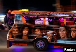 Commuters hang on to the back of a crowded jeepney in Cainta, Rizal, Philippines, Feb. 1, 2019.