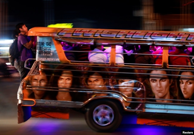 Commuters hang on to the back of a crowded jeepney in Cainta, Rizal, Philippines, Feb. 1, 2019.