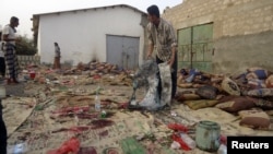 A man holds burnt garments at the site of a suicide bombing in Yemen's southern city of Jaar August 5, 2012.