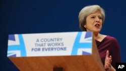 British Prime Minister Theresa May addresses delegates at the Conservative Party Conference at the ICC, in Birmingham, England, Oct. 5, 2016. May's government alarmed liberals by saying that businesses should prioritize hiring Britons.