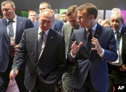 Russian President Vladimir Putin, left, listens as France's President Emmanuel Macron speaks to him at the G-20 summit in Buenos Aires, Nov. 30, 2018.