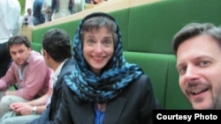 Barbara Slavin, wearing the required headscarf, and Thomas Erebrink of the New York Times, await Hassan Roouhani's swearing-in in Iranian parliament August 4.