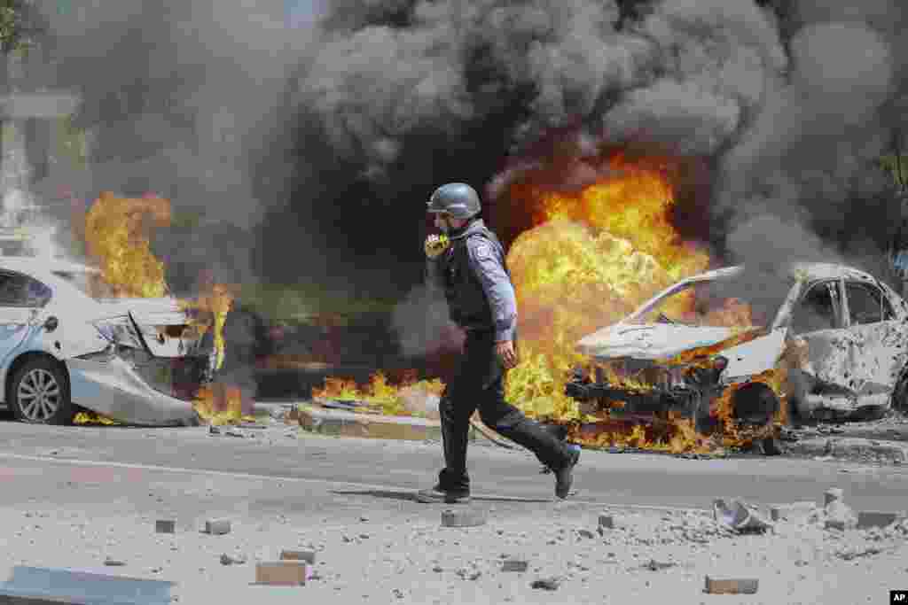 An Israeli firefighter walks next to cars hit by a missile fired from Gaza Strip, in the southern Israeli town of Ashkelon.