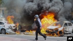 Um bombeiro israelita caminha perto de carros atingidos por um míssil disparado da Faixa de Gaza, na cidade israelita de Ashkelon, terça-feira, 11 de Maio de 2021.