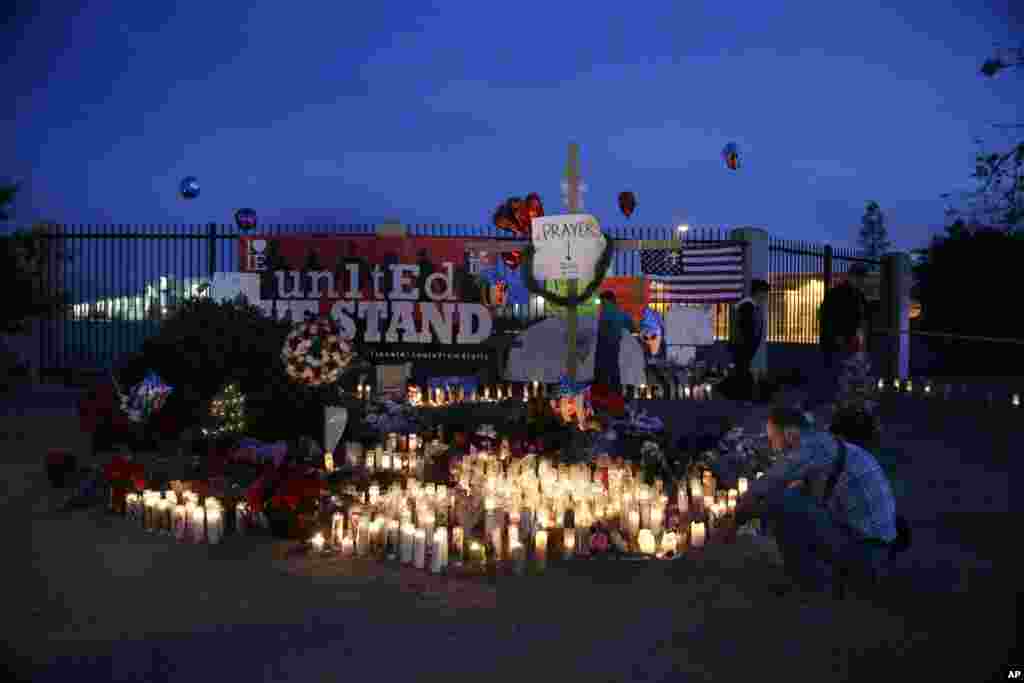 People pay respects at a makeshift memorial honoring the victims of Wednesday's shooting rampage, Dec. 5, 2015, in San Bernardino, Calif. 