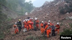 Des secouritstes recherchent des disparus emportés dans un éboulement sur le site d'une compagnie minière à Shangluo, dans la province du Shaanxi, Chine, 12 aout 2015