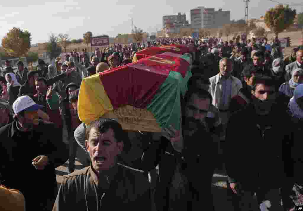 Mourners carry the coffin of a Kurdish fighter, killed while fighting Islamic State militants in Kobani, Syria, Oct. 23, 2014.