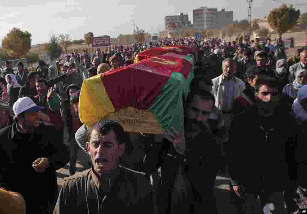 Warga mengusung peti jenazah pejuang Kurdi, yang tewas saat bertempur dengan militan ISIS di Kobani, Suriah (23/10).&nbsp;(AP/Lefteris Pitarakis) 