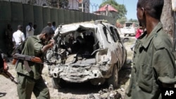 FILE - Security forces inspect the scene of a car bomb attack in the capital Mogadishu, Somalia, April 11, 2016. A car bomb exploded outside a restaurant packed with lunchtime customers, killing at least five people according to witnesses.