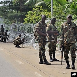 Armed members of the New Forces adopt combat positions near the hotel that houses the rival government declared by Alassane Ouattara in Abidjan, Ivory Coast, 13 Dec 2010