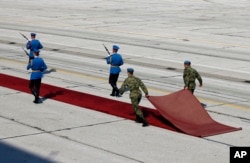 Gardisti Vojske Srbije uklanjaju crveni tepih nakon ceremonije.