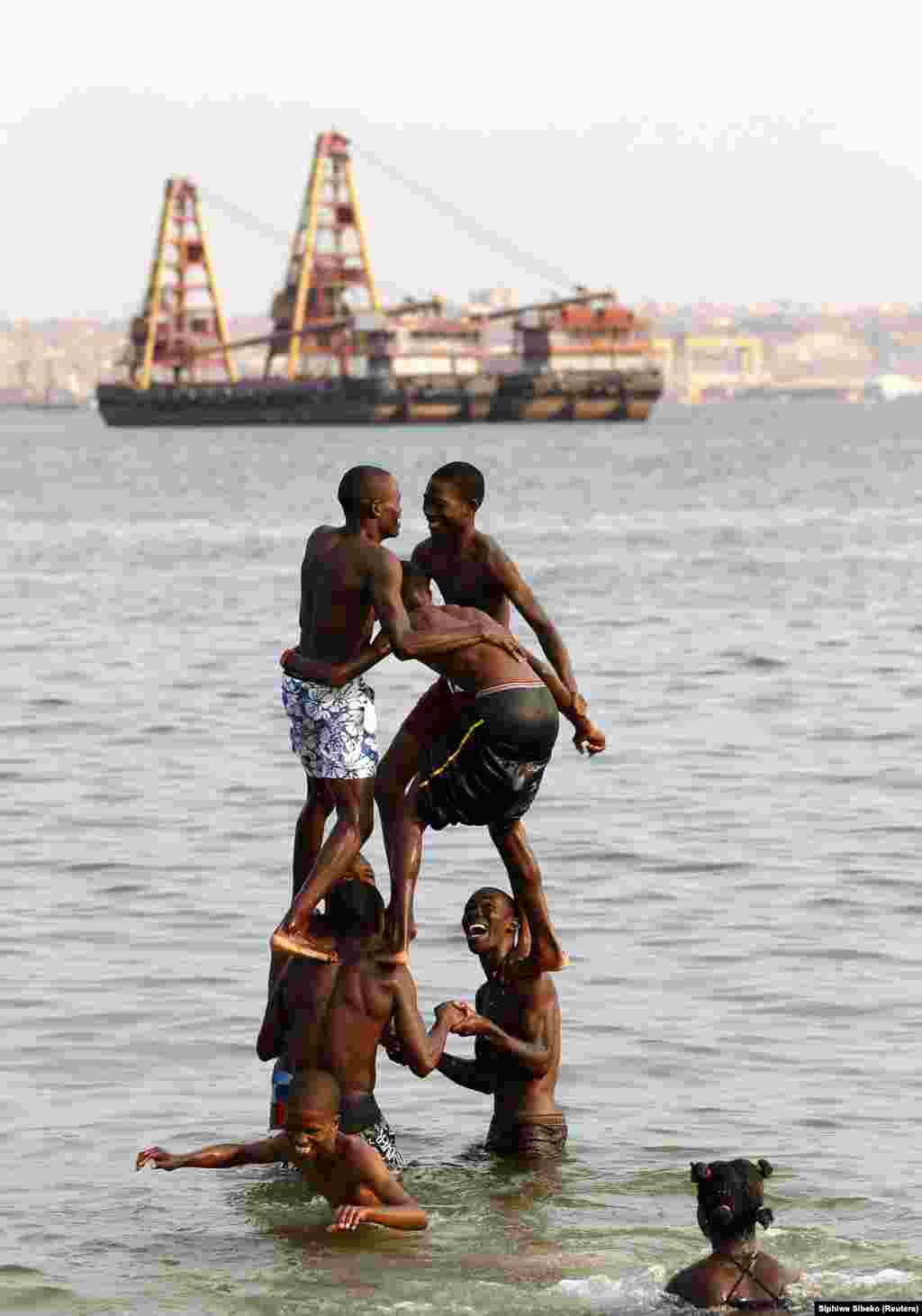 Jovens brincam numa praia em Luanda