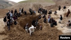 Afghan villagers gather at the site of a landslide at the Argo district in Badakhshan province, May 4, 2014.