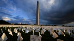 With the Washington Monument in the background, a note is seen on a white flag that is part of Suzanne Brennan Firstenberg's temporary art installation, "In America, How could this happen," in remembrance of American COVID-19 victims, on the National Mall in Washington, Sept. 17, 2021.