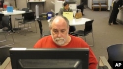 FILE - Richard Mattos, 59, looks for jobs at state-run employment center in Salem, Oregon.
