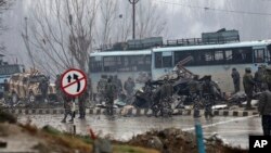 Indian paramilitary soldiers stand by the wreckage of a bus after an explosion in Pampore, Indian-controlled Kashmir, Feb. 14, 2019. 