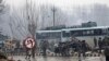 FILE - Indian paramilitary soldiers stand by the wreckage of a bus after an explosion in Pampore, Indian-controlled Kashmir, Thursday, Feb. 14, 2019. 