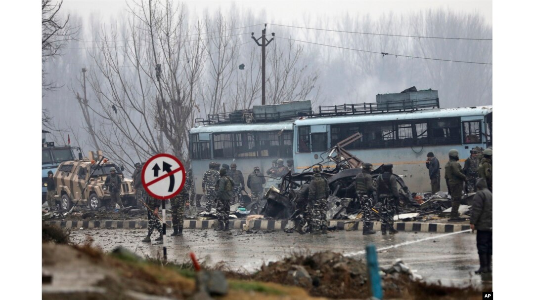 FILE - Indian paramilitary soldiers stand by the wreckage of a bus after an explosion in Pampore, Indian-controlled Kashmir, Feb. 14, 2019.