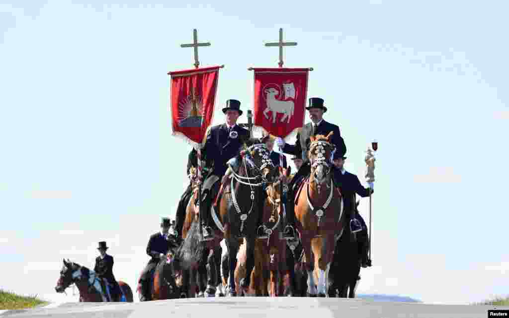 Sorbian men dressed in black tailcoats ride decorated horses during an Easter rider procession near Crostwitz, Germany.