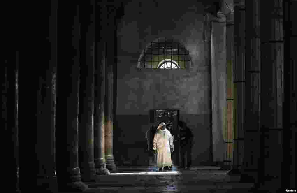 A nun walks inside the Church of the Nativity ahead of Christmas in the West Bank town of Bethlehem, Dec. 23, 2013.