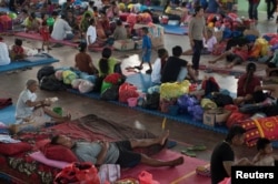 Villagers rest at a temporary evacuation center for people living near Mount Agung, a volcano on the highest alert level, inside a sports arena in Klungkung, on the resort island of Bali, Indonesia, Sept. 28, 2017, in this photo taken by Antara Foto.