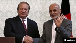 Afghan President Ashraf Ghani (R) shakes hands with Pakistani Prime Minister Nawaz Sharif after a news conference in Kabul, May 12, 2015. 