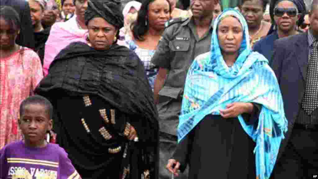 Turai Yar'Adua, wife of late President Umaru Yar'Adua, stands with Patience Jonathan as her husband's body is loaded into a plane to be transported for burial in Katsina, May 2010.