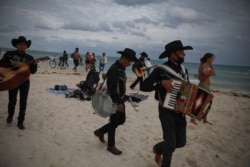 Musisi keliling "Los Compas" mencari turis untuk mengamen di pantai Mamitas, di Playa del Carmen, negara bagian Quintana Roo, Meksiko, Selasa, 5 Januari 2021.