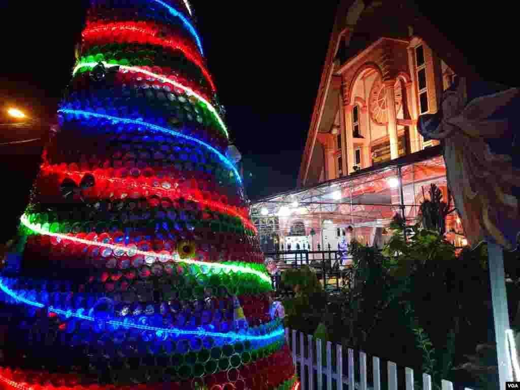 Pohon Natal setinggi 3 meter yang terbuat dari gelas plastik bekas minumal mineral menghiasi Gereja GKST Maranatha Kawua, kecamatan Poso Kota Selatan, Kabupaten Poso. Sulawesi Tengah, 24 Desember 2018. (Foto: Yoanes Litha/VOA)