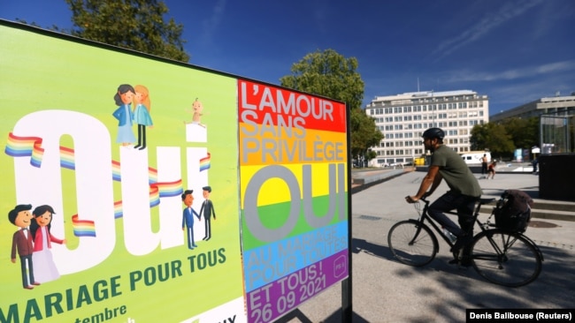 Tampak sebuah poster bertuliskan, "Cinta tanpa hak khusus, katakan 'Yes' untuk perkawinan bagi semua" terpasang di jalanan di Jenewa, Swiss, pada 23 September 2021. Swiss baru saja meloloskan peraturan yang mengakui pernikahan sesama jenis. (Foto: Reuters/Denis Balibouse)