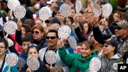 People wave images of Pope Francis as they wait for him to arrive for a Mass at the Cathedral Basilica of Saints Peter and Paul in Philadelphia, Sept. 26, 2015. 