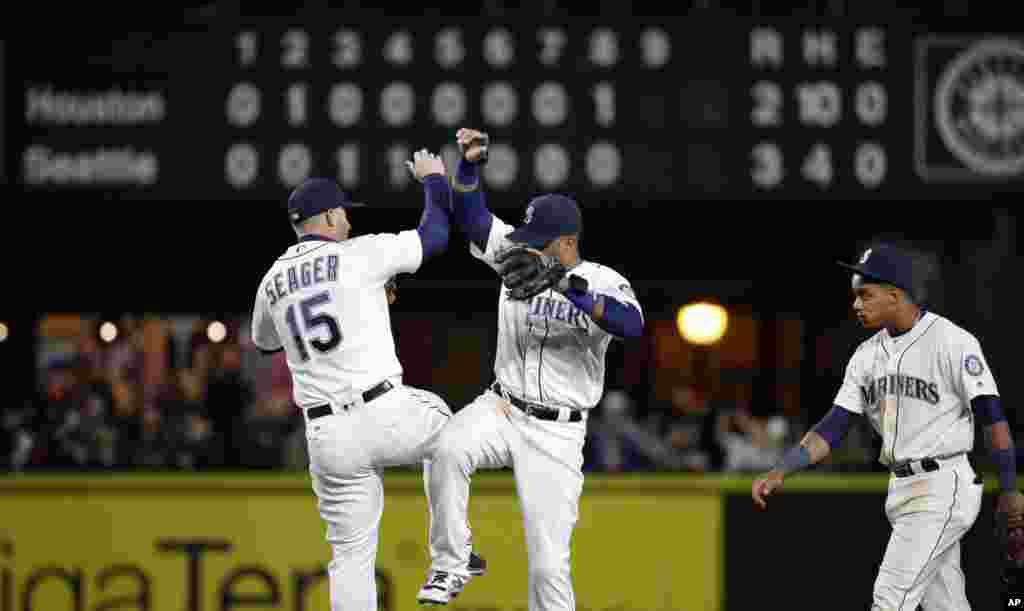 Seattle Mariners&#39; Kyle Seager (15) and Robinson Cano share congratulations as Ketel Marte looks on after the team beat the Houston Astros in a baseball game on April 25, 2016, in Seattle.