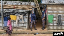 In this picture taken on October 5, 2021 members of the Armed Police Battalion (APBN) stand guard near the office of top community Rohingya leader and activist Mohib Ullah, who was shot dead by gunmen in late September.
