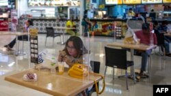 Sebagian pengunjung di sebuah pusat perbelanjaan di Surabaya di tengah pandemi virus corona, 10 Juni 2020. (Foto: AFP)