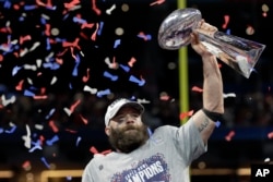 New England Patriots' Julian Edelman holds the trophy after the NFL Super Bowl 53 football game against the Los Angeles Rams, Sunday, Feb. 3, 2019, in Atlanta.