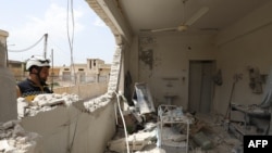 A member of the Syrian Civil Defense (The White Helmet) checks the rubble and debris at a medical center following reported shelling by the Syrian government, in Hbeit in the southern countryside of the rebel-held Idlib province, April 30, 2019.