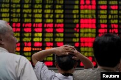 중국 상하이의 증권사에서 투자자들이 주식 정보를 보고 있다.