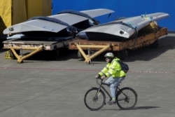 FILE - A worker leaves the Boeing Everett Factory on a bicycle, amid the coronavirus disease (COVID-19) outbreak, in Everett, Washington, U.S. March 23, 2020. (REUTERS/David Ryder)