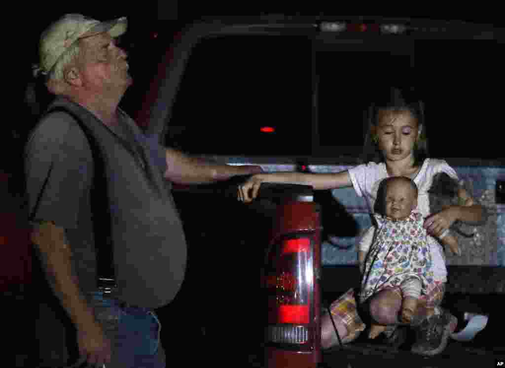 Seven-year-old Katrina Ash holds a doll as she waits in the back of a truck with her grandfather, Michael Bowen, after a tornado ripped through their neighborhood near Dale, Oklahoma, May 19, 2013. 