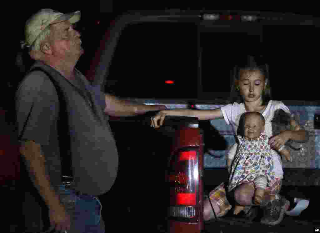 Un hombre trata de abandonar el &aacute;rea afectada junto a una ni&ntilde;a. 