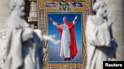 The tapestry with the image of Pope Paul VI is unveiled as Pope Francis celebrates the mass for his beatification in St. Peter's Square at the Vatican, Oct. 19, 2014. 